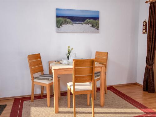 a dining room with a table and chairs and the beach at Apartment Schleichert-1 by Interhome in Barkholt