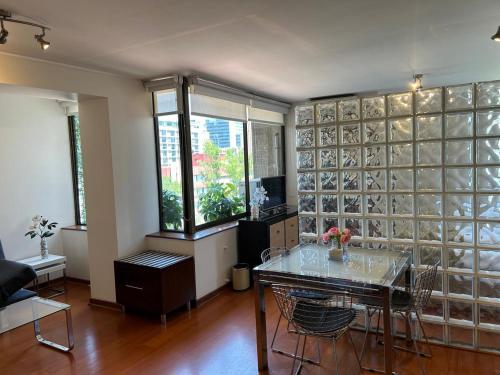 a living room with a table and a glass wall at II Orly Suites Pedro de Valdivia 0200 in Santiago