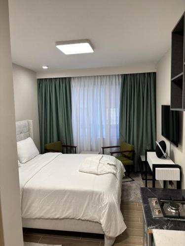 ナイロビにあるMatarimo Homes Apartmentのベッドと机と窓のある寝室