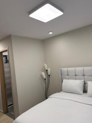 ナイロビにあるMatarimo Homes Apartmentのベッドルーム(白いベッド、ライト付)