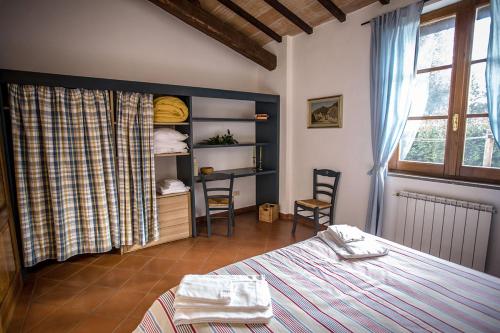 a bedroom with a bed and a table and chairs at Tenuta di Paganico - I Roggeti in Paganico