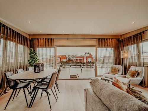 a living room with a table and a couch at Holiday Home De Woude by Interhome in Uitgeest