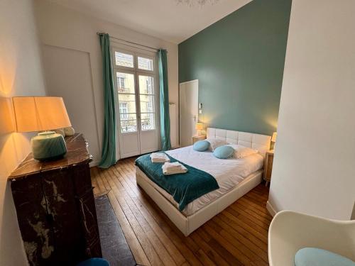 une chambre avec un lit avec des oreillers bleus et une fenêtre dans l'établissement Les Lys d'Or, à Saumur