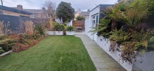 a small garden with grass and plants on a building at Extended 3BD SplitLevel Cottage in Popular Village in Dublin