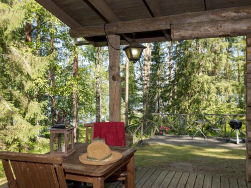 a hat sitting on a wooden table on a deck at Holiday Home Rinnekämppä by Interhome in Pätiälä