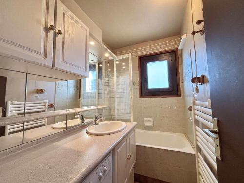 La salle de bains blanche est pourvue d'un lavabo et d'une baignoire. dans l'établissement Appartement 3 pièces, 8 pers., balcon, piscine, au pied des pistes - Notre-Dame-de-Bellecombe - FR-1-595-6, à Notre-Dame-de-Bellecombe