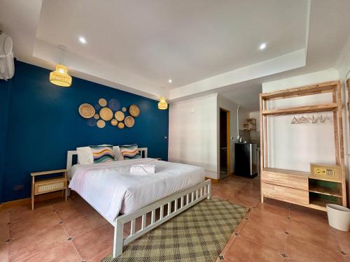 a bedroom with a large bed and a blue wall at Charm Hostel at Jomtien in Jomtien Beach