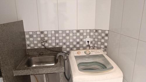 a small bathroom with a toilet and a sink at Central apartmento em Aperibé in Aperibé
