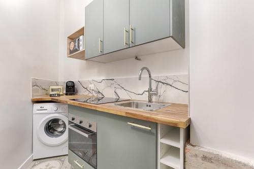 une cuisine avec un évier et une machine à laver dans l'établissement Appartement Duplex Atypique au coeur du Sentier, à Paris