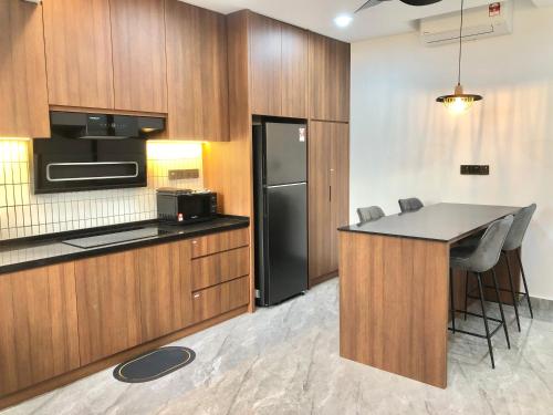 a kitchen with wooden cabinets and a black refrigerator at BigLanded House NR Penang Hill & Kek Lok Si Temple in Ayer Itam
