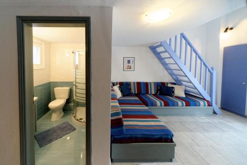 Zimmer mit Sofa und Treppenaufgang in der Unterkunft Machi Studios in Neo Klima