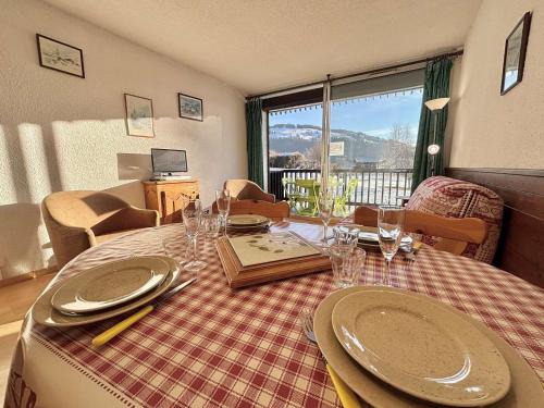 une salle à manger avec une table avec des assiettes et des verres à vin dans l'établissement Confortable studio 4 personnes avec piscine et parking à Notre-Dame-de-Bellecombe - FR-1-595-34, à Notre-Dame-de-Bellecombe