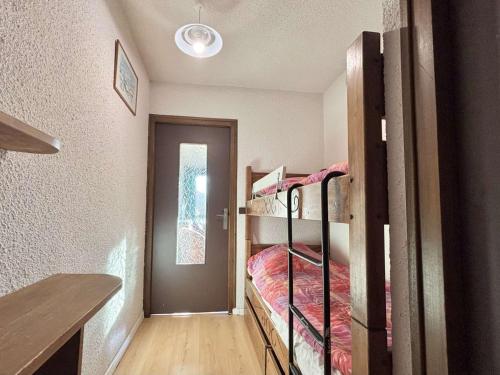 Cette chambre comprend 2 lits superposés et une porte. dans l'établissement Confortable studio 4 personnes avec piscine et parking à Notre-Dame-de-Bellecombe - FR-1-595-34, à Notre-Dame-de-Bellecombe