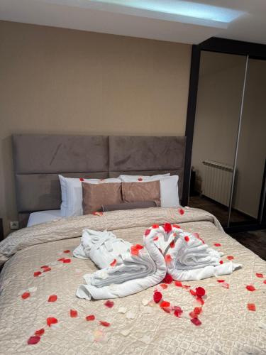 a bed with red rose petals on it at Guest House Panorama Aqualux with Free Parking in Novi Sad