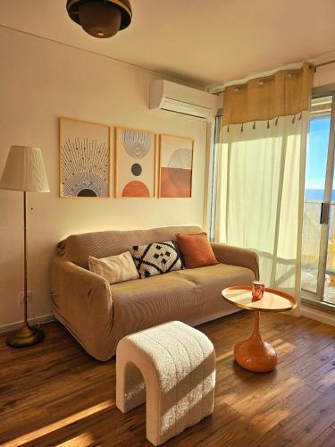 un salon avec un canapé et une table dans l'établissement LE MARTY 46, Jolie Déco, Vue Mer, Climatisation, Parking Privé, Piscine, à Sète