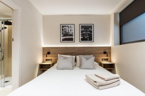 a bedroom with a white bed with towels on it at Petit Luxe Mutua in Terrassa