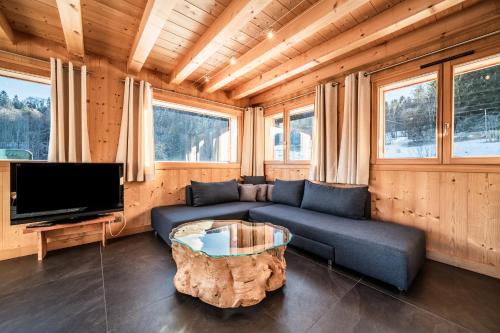 a living room with a couch and a tv at Chalet Le Mas Devant in Morillon