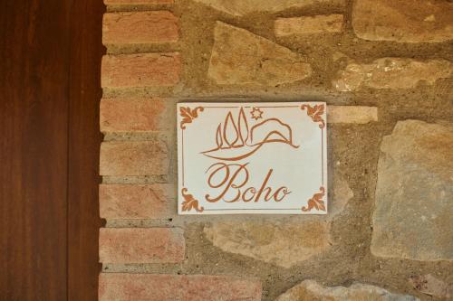 a sign on the side of a brick wall at Glamping Le Dune in Cinigiano