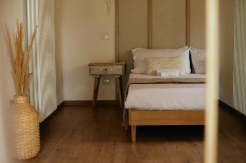 a bedroom with a bed and a side table at Glamping Le Dune in Cinigiano