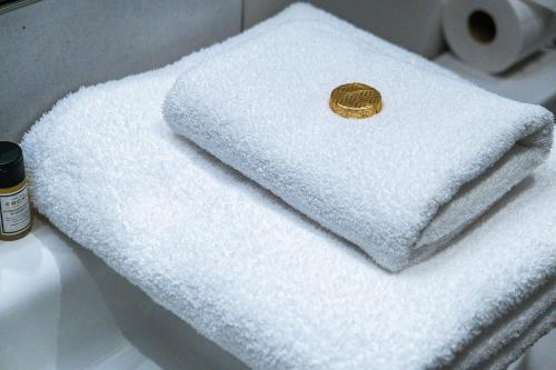 a white towel with a gold coin on it at Osbourne House - BLUE 2 Bedroom,2 and half bath in Birmingham