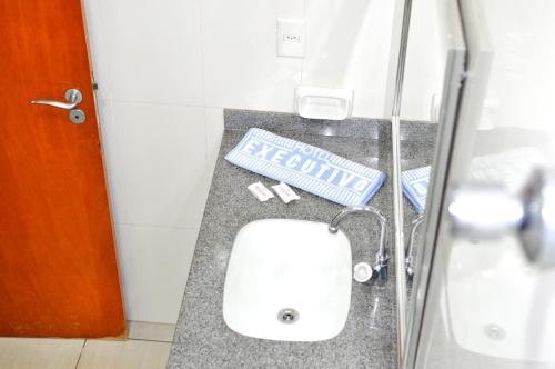 a bathroom with a sink and a shower stall at Hotel Executivo in Araguaína