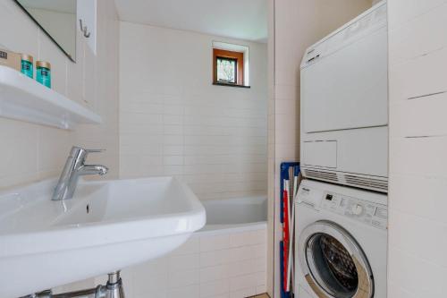 a bathroom with a sink and a washing machine at Dutchen Vakantiepark Buiten Bergen in Schoorl