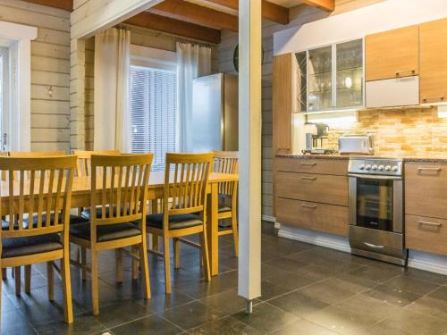 eine Küche mit einem Holztisch und Stühlen in der Unterkunft Holiday Home Uulanlinna a- paritalo by Interhome in Hyrynsalmi