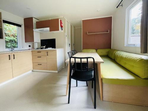 a small kitchen with a couch and a table in a room at Holiday Home De Brenkberg-1 by Interhome in Schinveld