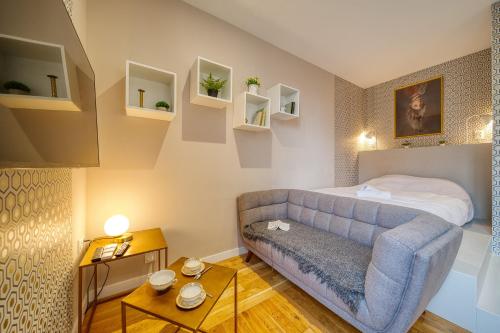 une chambre avec un canapé bleu et un lit dans l'établissement R'Apparts Studio Art Deco, à Grenoble