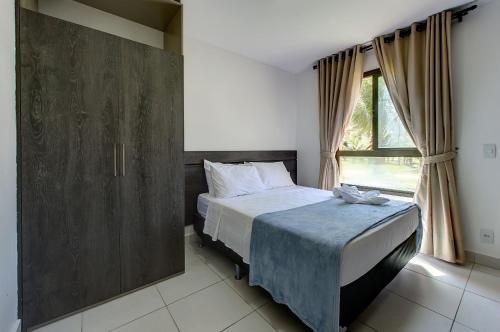 a bedroom with a bed and a large window at VG Sun Cumbuco Térreo WiFi Ar Cond 4 Pessoas in Paracumbuca