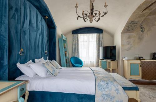 ein Schlafzimmer mit einem großen Bett mit blauer Wand in der Unterkunft MAGISTER seven in Sibiu