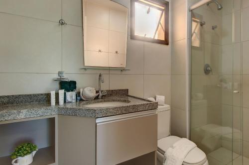 a bathroom with a toilet and a sink and a shower at VG Sun Cumbuco Térreo WiFi Ar Cond 4 Pessoas in Paracumbuca