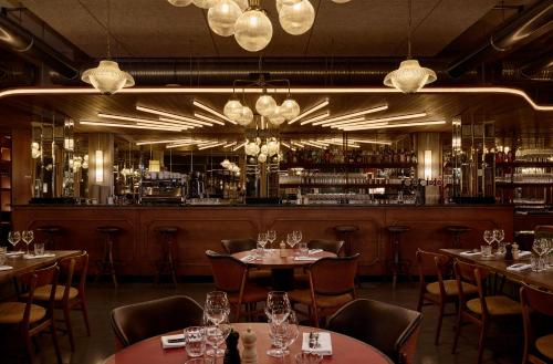 a restaurant with tables and chairs and a bar at Grand Mess Clermont-Ferrand in Clermont-Ferrand