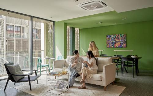 two women sitting on a couch in a living room at Express by M Village Global City in Ho Chi Minh City