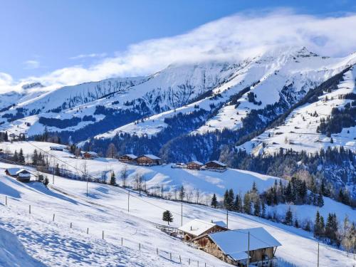 a snow covered mountain with houses and a ski slope at Apartment Bühl by Interhome in Achseten