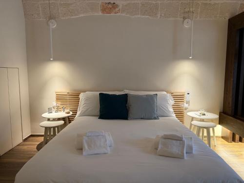 a bedroom with a large bed with two tables at La Casupola by MONHOLIDAY in Monopoli