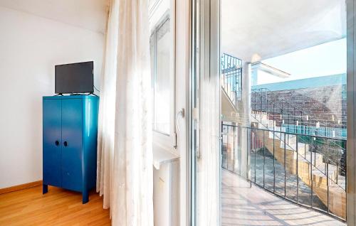 Cette chambre comprend une armoire bleue et une grande fenêtre. dans l'établissement Beautiful Apartment In Schiltigheim, à Schiltigheim