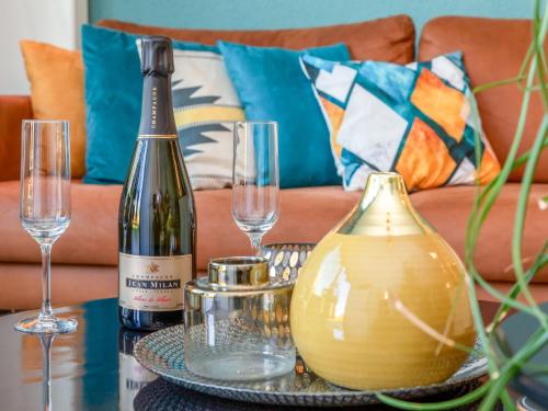 a table with a bottle of wine and glasses on it at Holiday Home Solipi by Interhome in Nieuwvliet-Bad