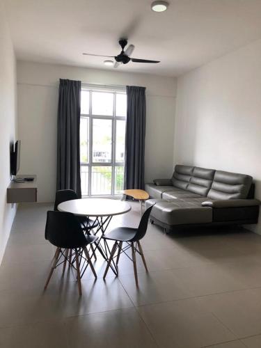 a living room with a couch and a table and chairs at Golden Hill 1 Room Apt at Night Market in Cameron Highlands