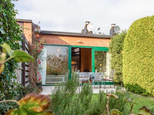 a patio with chairs and tables in a garden at Holiday Home Zonnehof Nieuwvliet-Bad by Interhome in Nieuwvliet-Bad