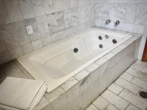 a large white bath tub in a bathroom at Casa Três Rios - Campos do Jordão in Campos do Jordão
