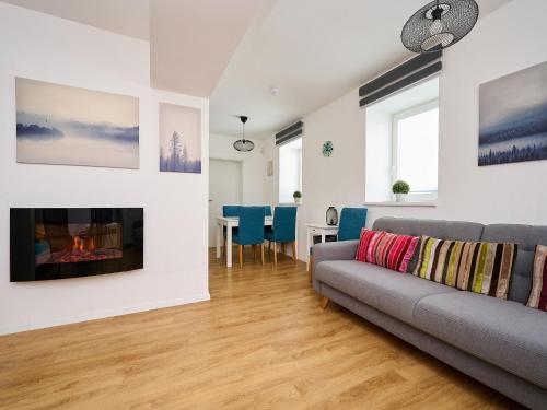 una sala de estar con un sofá y una chimenea en Apartment Hašlerka by Interhome, en Janov nad Nisou