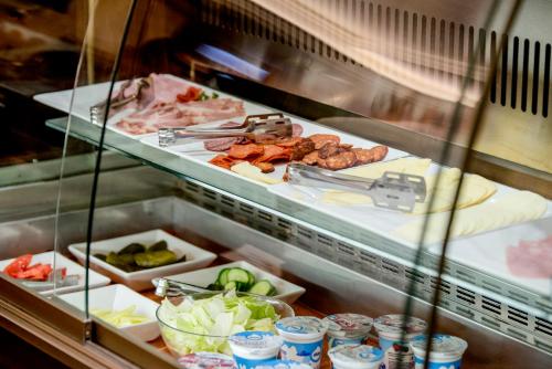 a display case in a restaurant with many food items at Gold Hotel Budapest in Budapest