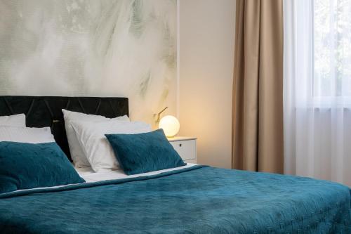 a bedroom with a bed with blue sheets and a window at Apartman casa Blanca in Podstrana