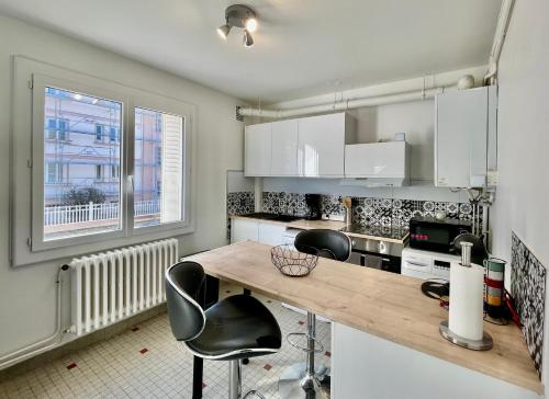 une cuisine avec des armoires blanches et un comptoir en bois dans l'établissement Appartement centre Vichy avec jardin, à Vichy
