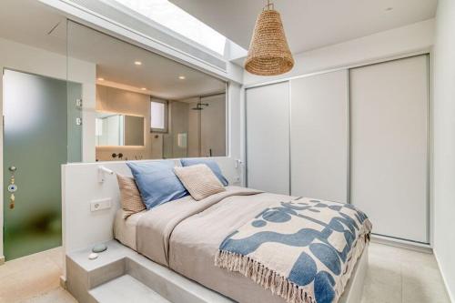 a bedroom with a large bed with blue pillows at Villa Gypsea - Paros in Aspro Chorio Paros