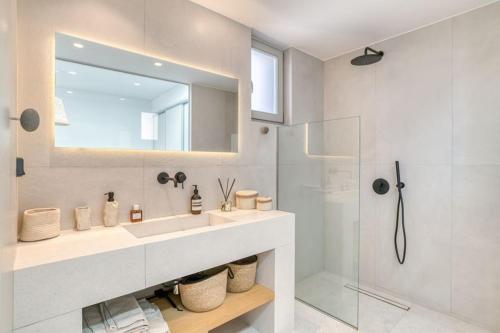 a bathroom with a sink and a mirror and a shower at Villa Gypsea - Paros in Aspro Chorio Paros