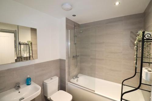 a bathroom with a toilet and a shower and a sink at High Wycombe Stunning Stylish Four Bedroom House in High Wycombe