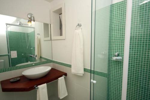 a bathroom with a sink and a glass shower at Passeio das Palmeiras in Búzios