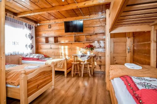 een slaapkamer met 2 bedden in een houten hut bij Willa Klimek Biały Dunajec in Zakopane